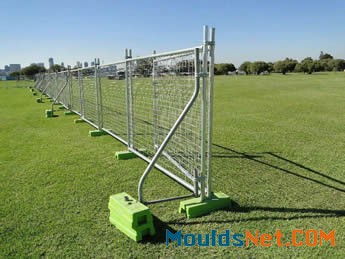 A row of welded temporary fences are installed on the grassland with stays on it.