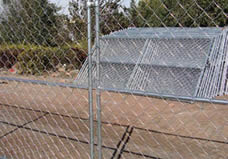 Two chain l<em></em>ink portable fence panel with the horizo<em></em>ntal cross bars are co<em></em>nnected by the clamp and green feet.