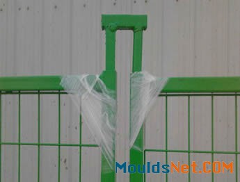 A green top coupler with round and square tubular legs are installed on the fence panel.