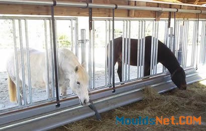 Two horses are enclosed in the feed barrier eating hay