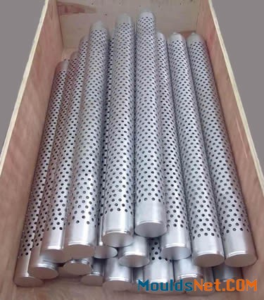 A lot of stainless steel perforated candle filters in a wooden box.